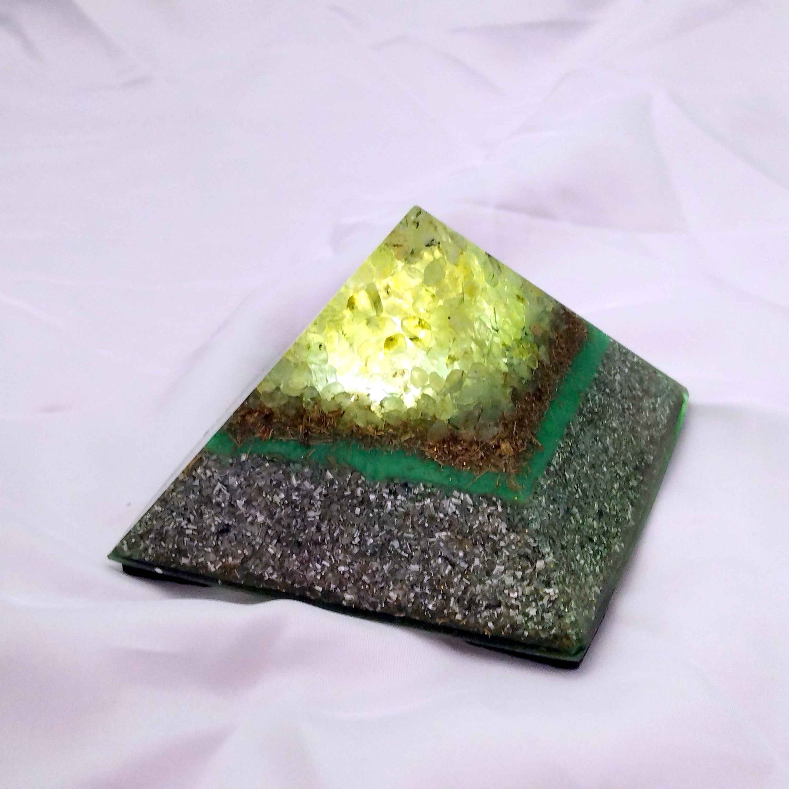 Pirámide de orgonita con luz interna y PREHNITA en su vértice.